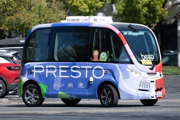 Autonomous shuttle bus with colorful design and the word "PRESTO" on the side.